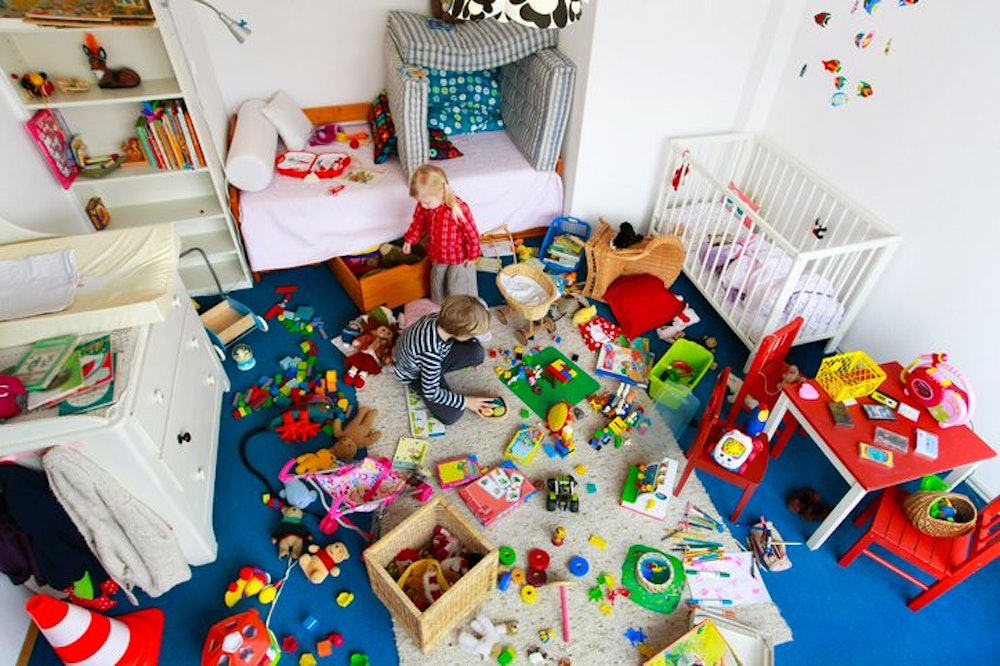 Zwei Kinder spielen in einem Raum voller Spielzeug.
