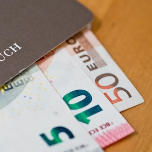 Euro-Geldscheine liegen in einem Sparbuch.