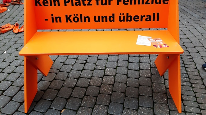 Eine orangefarbene Bank mit der Aufschrift „Kein Platz für Femizide – in Köln und überall“ wurde auf der Schildergasse aufgestellt.