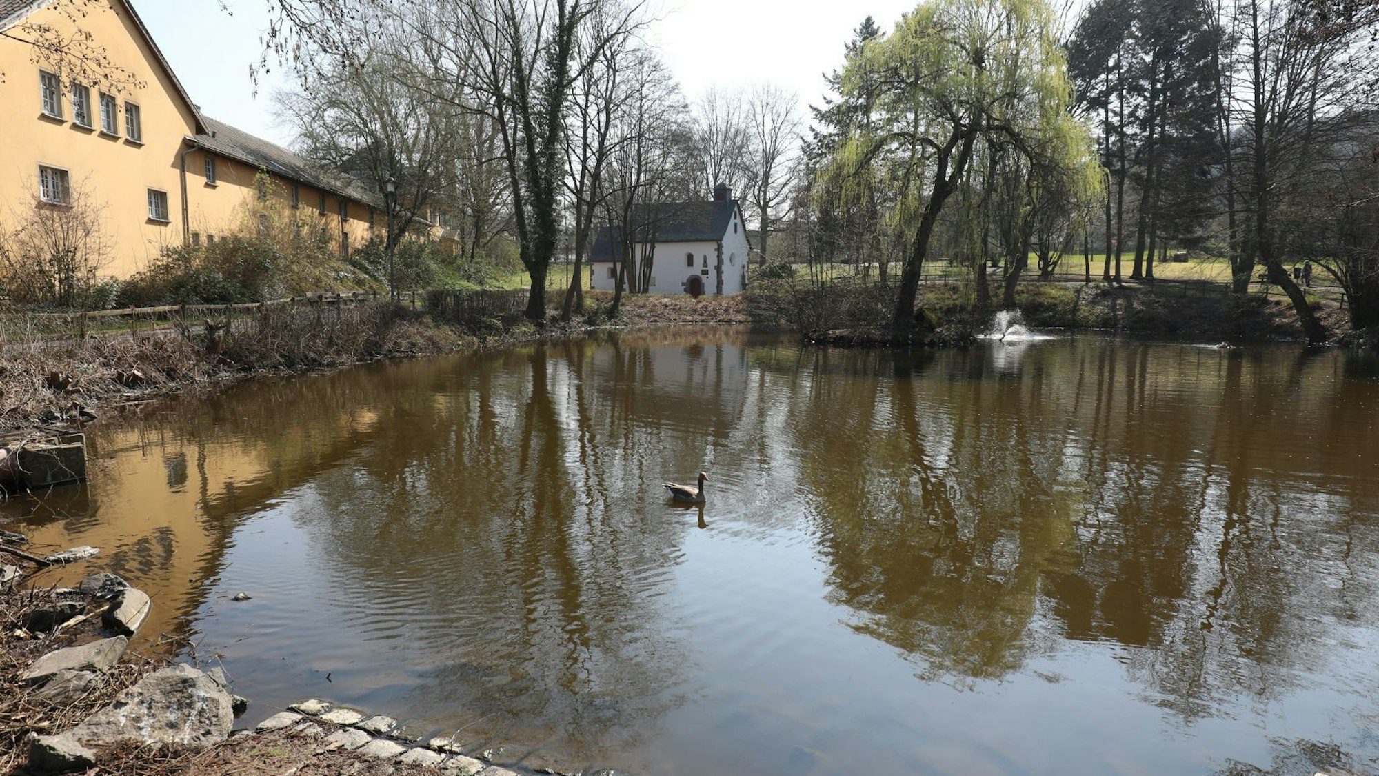 Ein kleiner Teich und im Hintergrund eine kleine Kapelle.
