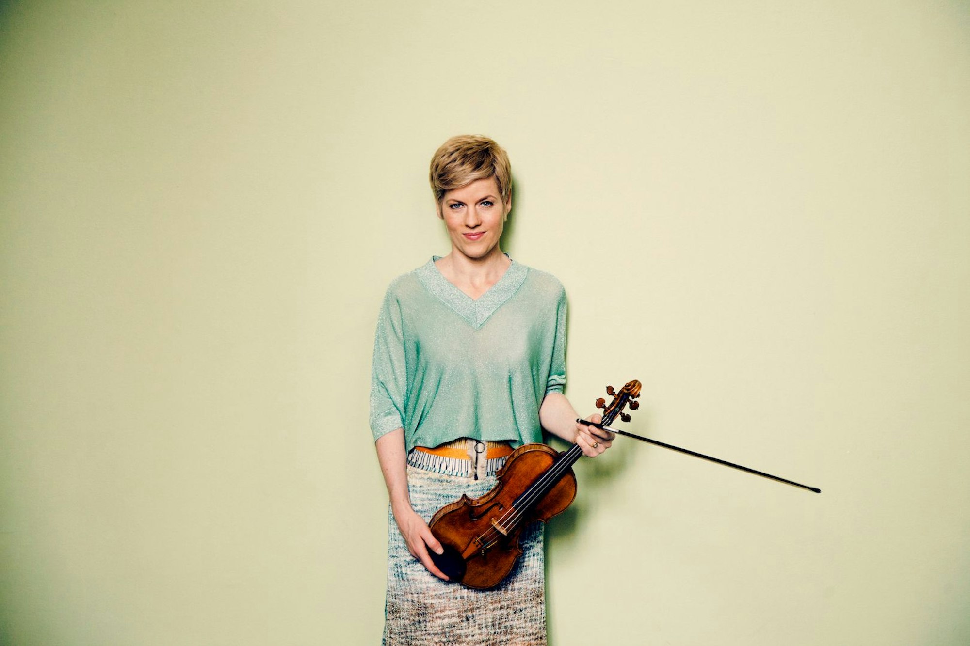 Die Solistin Isabelle Faust, sie hält ihre Geige mit beiden Händen