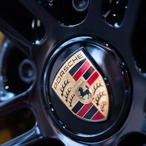 Das Logo des Autobauers Porsche ist auf einer Felge im Porsche Zentrum Stuttgart zu sehen.