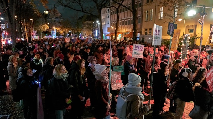 Teilnehmerinnen und Teilnehmer der Protest-Veranstaltung „Wir nehmen uns die Nacht“ zum Internationalen Tag gegen Gewalt an Frauen stehen auf dem Hans-Böckler-Platz in Köln.
