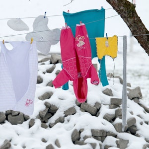Kleidung hängt bei frostigen Temperaturen auf einer Wäscheleine.