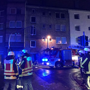 Autos und Einsatzkräfte der Feuerwehr stehen vor einem Mehrfamilienhaus in Bochum. Bei einem Brand ist eine Person ums Leben gekommen.