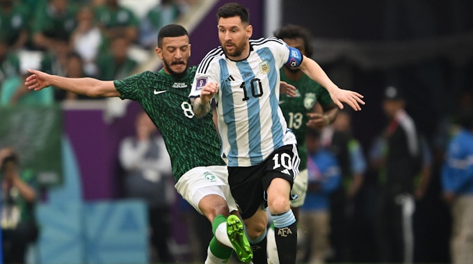 Argentiniens Lionel Messi (r) und Saudi-Arabiens Abdulelah Almalki im Zweikampf.