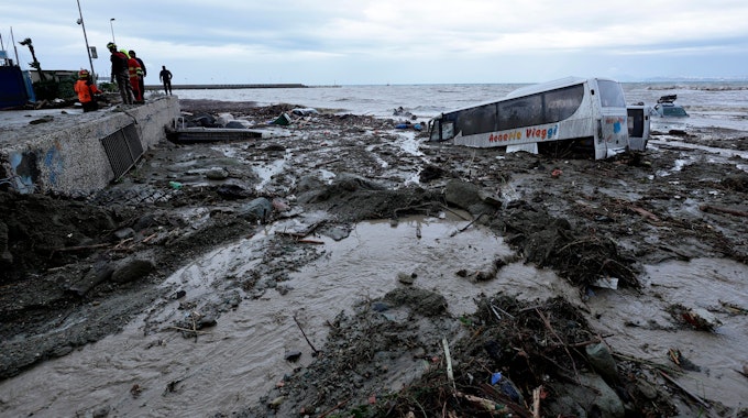 Rettungskräfte stehen in Casamicciola auf Ischia neben einem Bus, der durch schwere Regenfälle weggeschwemmt wurde.