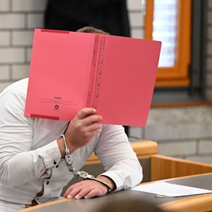 Der Angeklagte im Prozess wegen Mordes an einer Sechsjährigen und Störung der Totenruhe wartet in einem Verhandlungssaal im Landgericht Baden-Baden auf den Prozessbeginn.