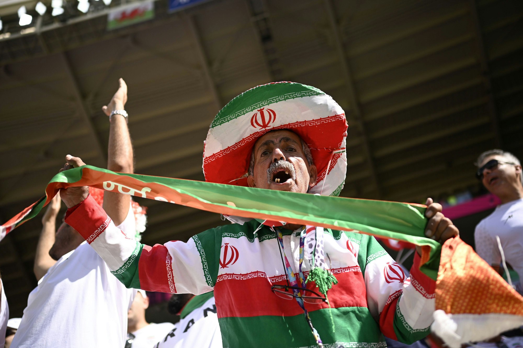 Ein Anhänger der iranischen Nationalmannschaft beim Spiel gegen Wales mit Iran-Hut, -Shirt und -Schal.