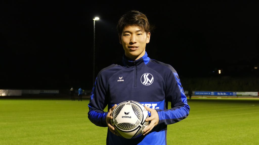 Kaito Asano vom Siegburger SV 04 steht mit einem Fußball in der Hand am Spielfeld.&nbsp;