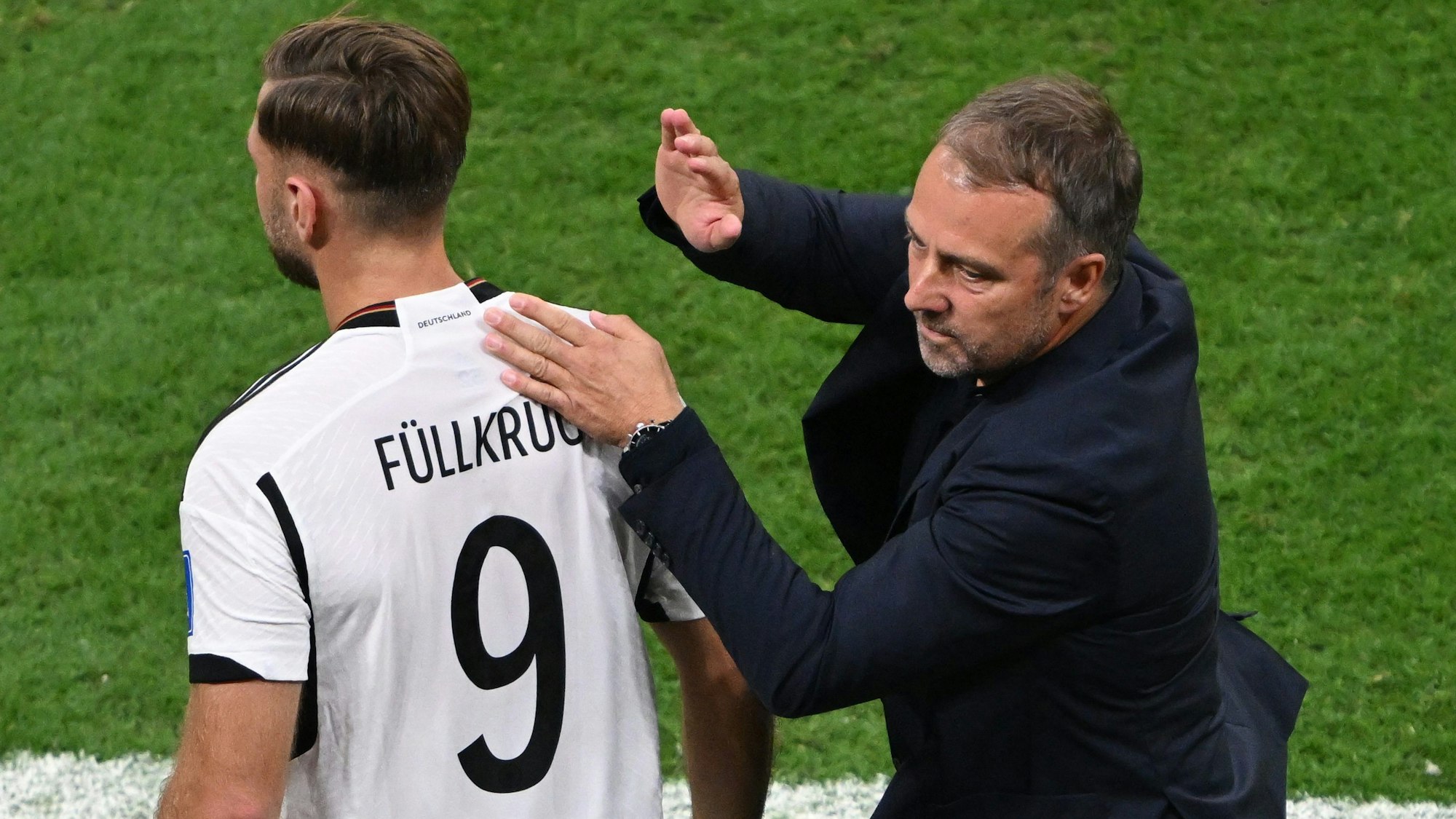 Trainer Hans-Dieter Flick klopft Deutschlands Torschützen Niclas Füllkrug nach dem Spiel auf die Schulter.