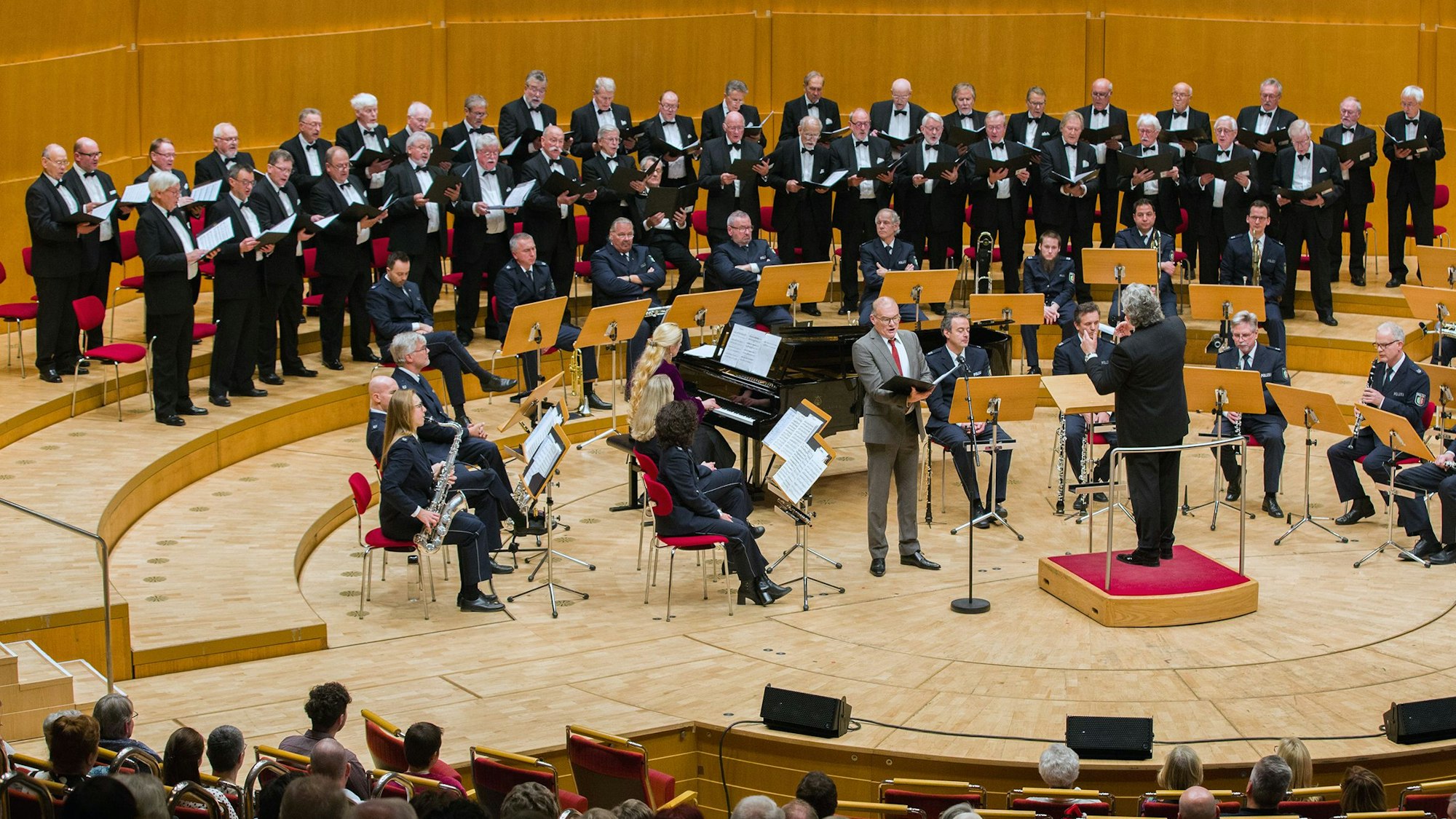 Konzert des Polizeichores Köln anlässlich seines 120-jährigen Bestehens in der Kölner Philharmonie. Zu sehen sind unter anderem Solist und Sänger Ansgar Eimann, Pianistin Alexandra Momot und Dirigent Eugen Momot.
