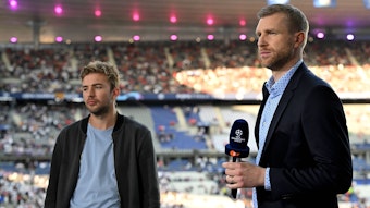 Gladbach-Profi Christoph Kramer (l.) und Per Mertesacker am 28. Mai 2022 beim Champions-League-Finale in Paris. Mertesacker hält ein Mikrofon in der rechten Hand.