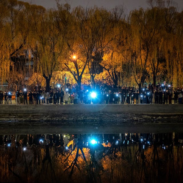 Protestierende in Peking halten ihre Handys in die Luft.
