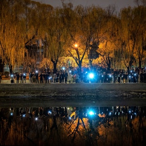 Protestierende in Peking halten ihre Handys in die Luft.