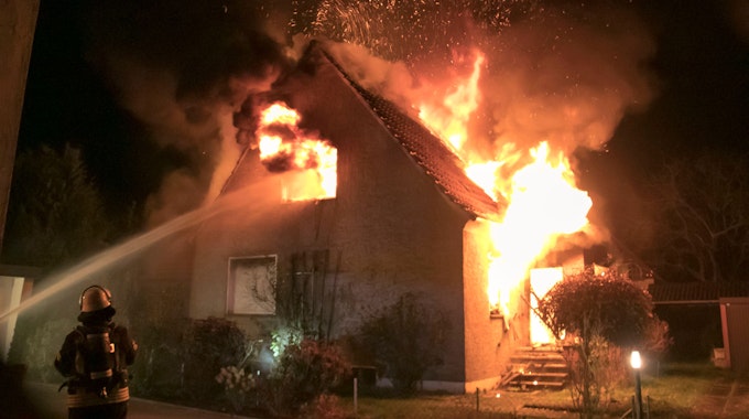 26.11.2022, Nordrhein-Westfalen, Lübbecke: Feuerwehrleute bekämpfen am frühen Morgen einen Brand in einem Einfamilienhaus. Das Gebäude sei in der Nacht auf Samstag komplett zerstört worden, sagte ein Sprecher der Polizei.