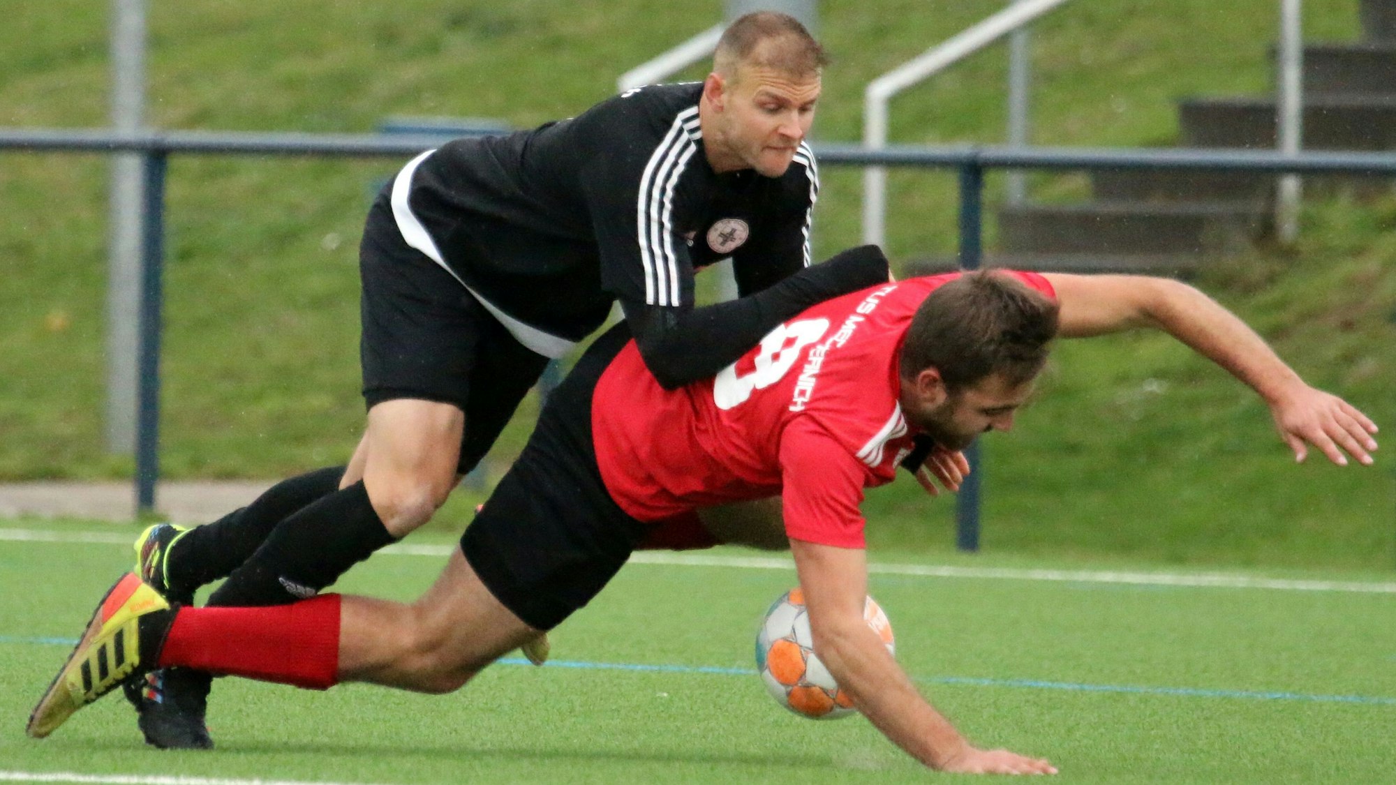 Der Zülpicher Spieler Markus Blum drückt von hinten Mechernichs Lukas Wollenweber zu Boden.