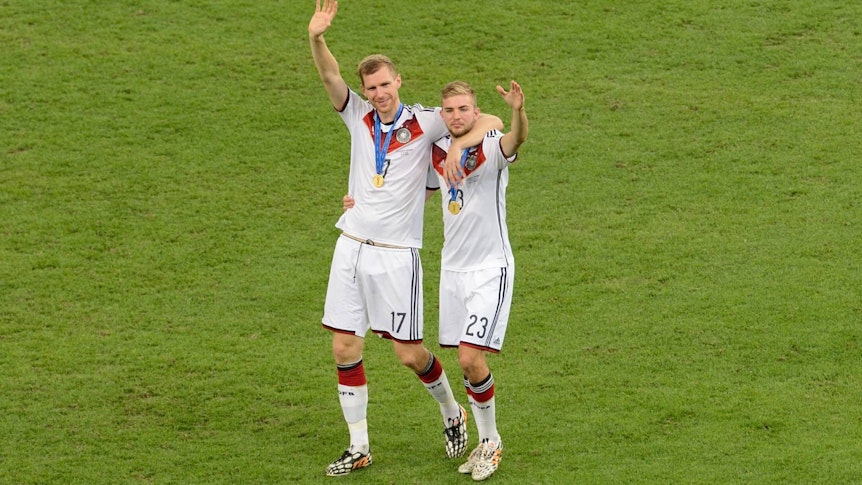 Per Mertesacker und Christoph Kramer gehen Arm in Arm nach dem gewonnenen WM-Finale 2014 über den Rasen des Maracanã in Rio. Sie tragen die goldenen Medaillen des Weltmeisters.