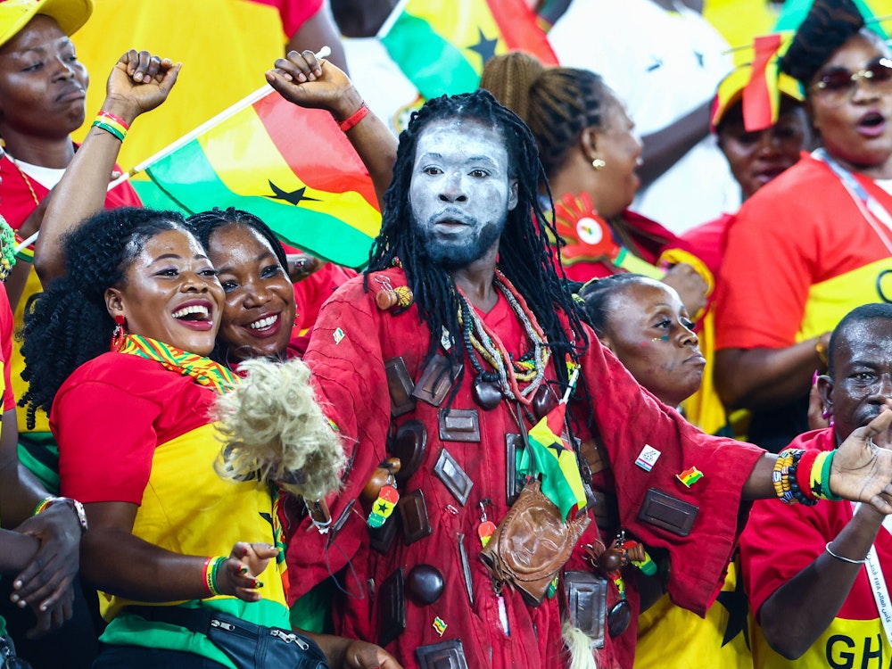 Ein Ghana-Fan mit weiß bemalten Gesicht und rotem Gewand schaut entsetzt auf der Tribüne.