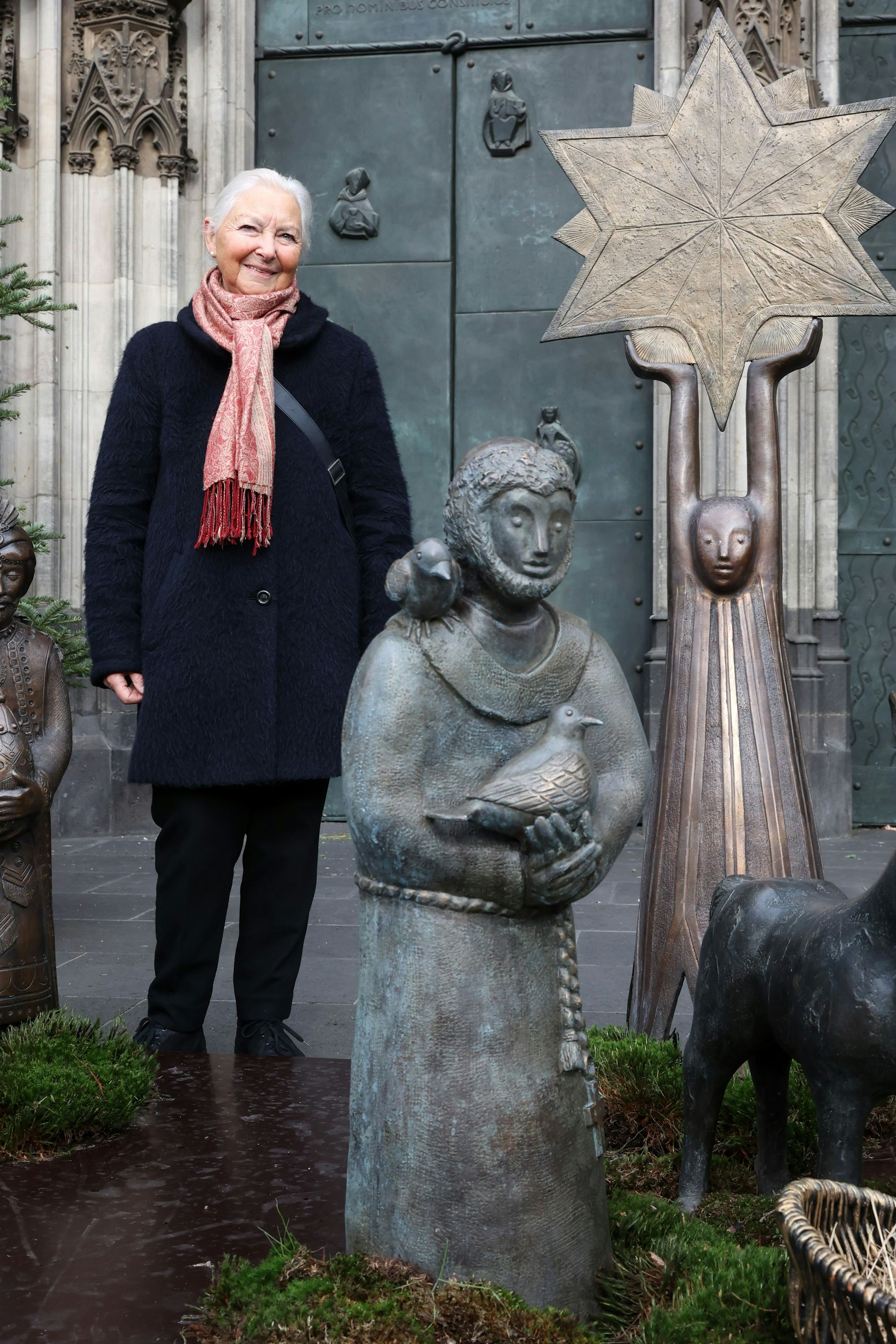 Das Bild zeigt Künstlerin Rosemarie Peter neben der neuen Bronzefigur, die sie als Ergänzung der Kölner Stadtkrippe geschaffen hat.