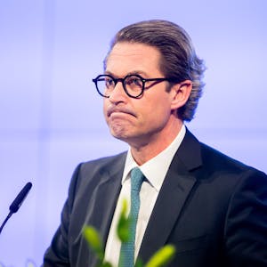 Ex-Bundesverkehrsminister Andreas Scheuer (CSU) vor einem Rednerpult mit zwei Mikrofonen.