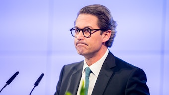 Ex-Bundesverkehrsminister Andreas Scheuer (CSU) vor einem Rednerpult mit zwei Mikrofonen.