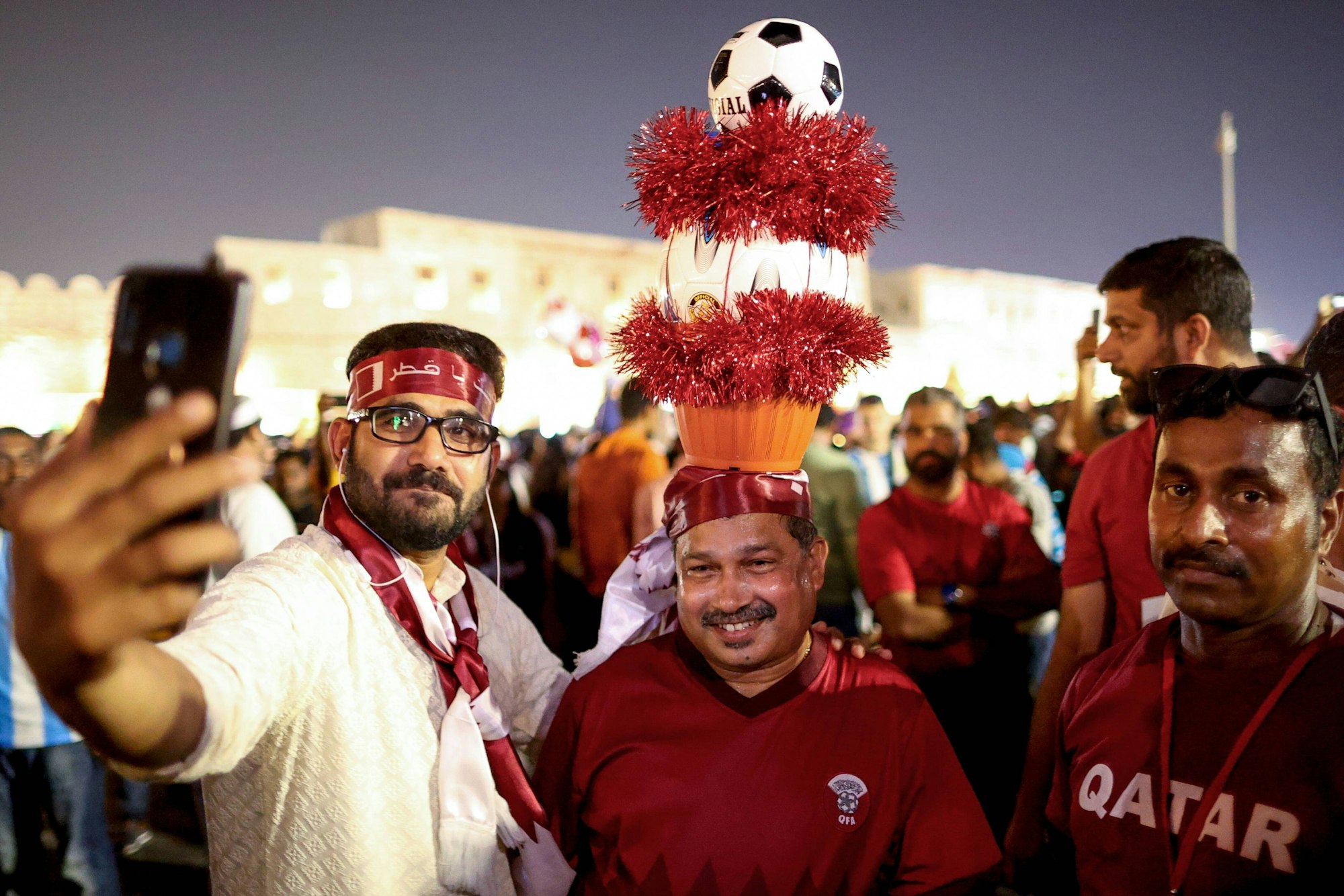Drei Fans der katarischen Nationalmannschaft im Vorfeld der Weltmeisterschaft, einer von ihnen hat eine kuriose Kopfbedeckung.