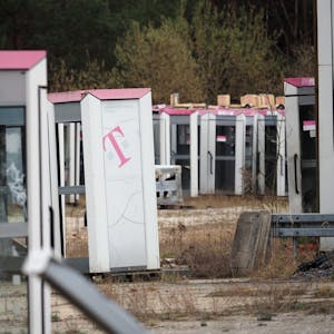 Ausrangierte Telefonzellen stehen auf einem abgezäunten Gelände in Brandenburg.