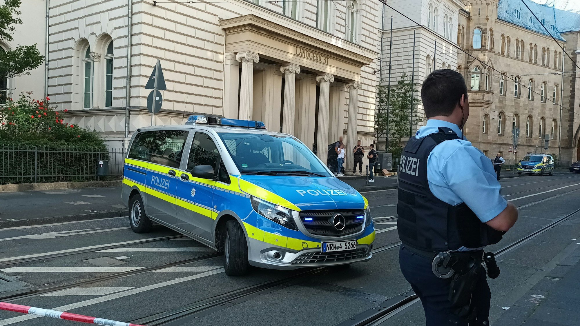 Ein Polizist steht hinter einem Flatterband vor dem Gebäude des Landgerichts Bonn.