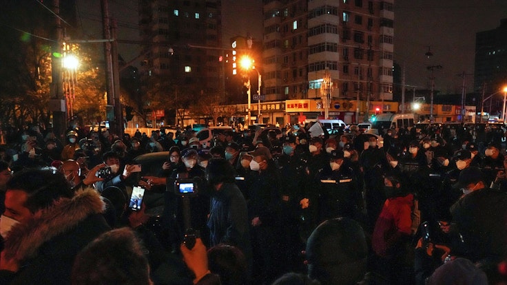 Demonstrierende stoßen mit Polizisten während einer Demonstration zusammen. In China hat die strenge Corona-Politik am Wochenende zu den größten Protesten seit Jahrzehnten geführt.