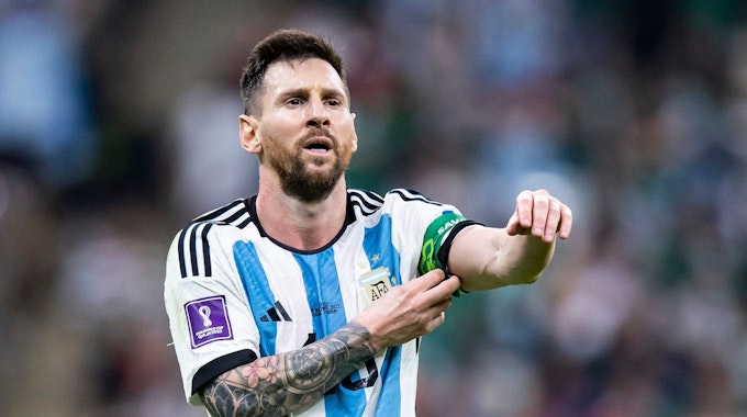 Lionel Messi rückt bei einem WM-Spiel mit Argentinien seine Kapitänsbinde zurecht