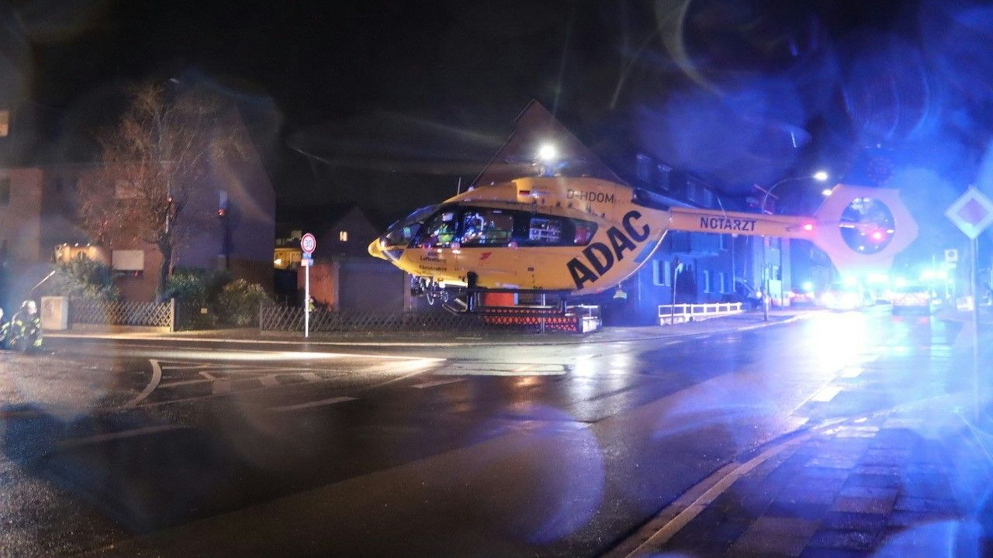 Ein Helikopter landet auf einer Straße in Hürth, im Hintergrund ist Blaulicht zu sehen.