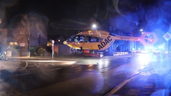 Ein Helikopter landet auf einer Straße in Hürth, im Hintergrund ist Blaulicht zu sehen.