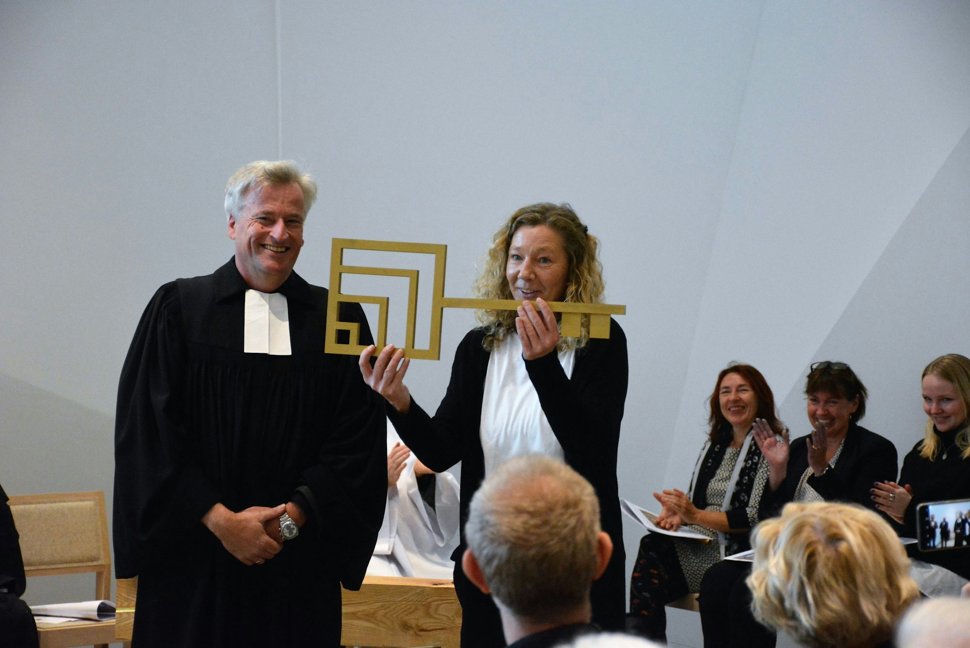 Pfarrer Markus Zimmermann und Küsterin Kerstin Müller bei der symbolischen Schlüsselübergabe während der Eröffnung der Erlöserkirche in Weidenpesch.