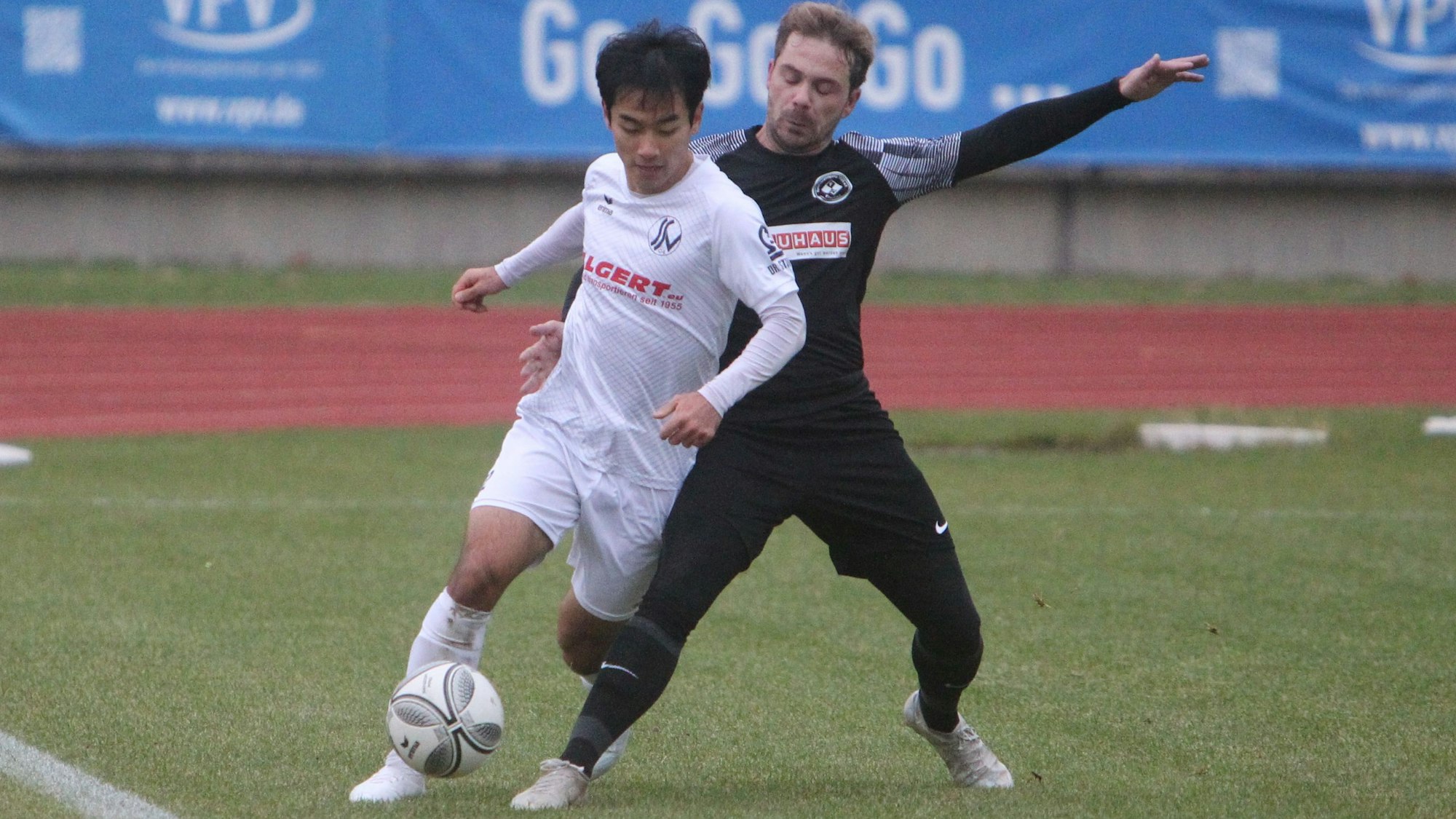 Ju-yong Jo (links) vom Siegburger SV 04 führt an der Seitenauslinie den Ball am Fuß, sein Frechener Gegenspieler stellt sein Bein dazwischen.