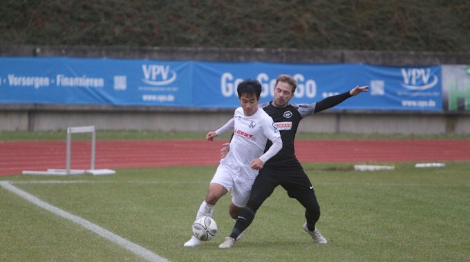 Ju-yong Jo (links) vom Siegburger SV 04 führt an der Seitenauslinie den Ball am Fuß, sein Frechener Gegenspieler stellt sein Bein dazwischen.