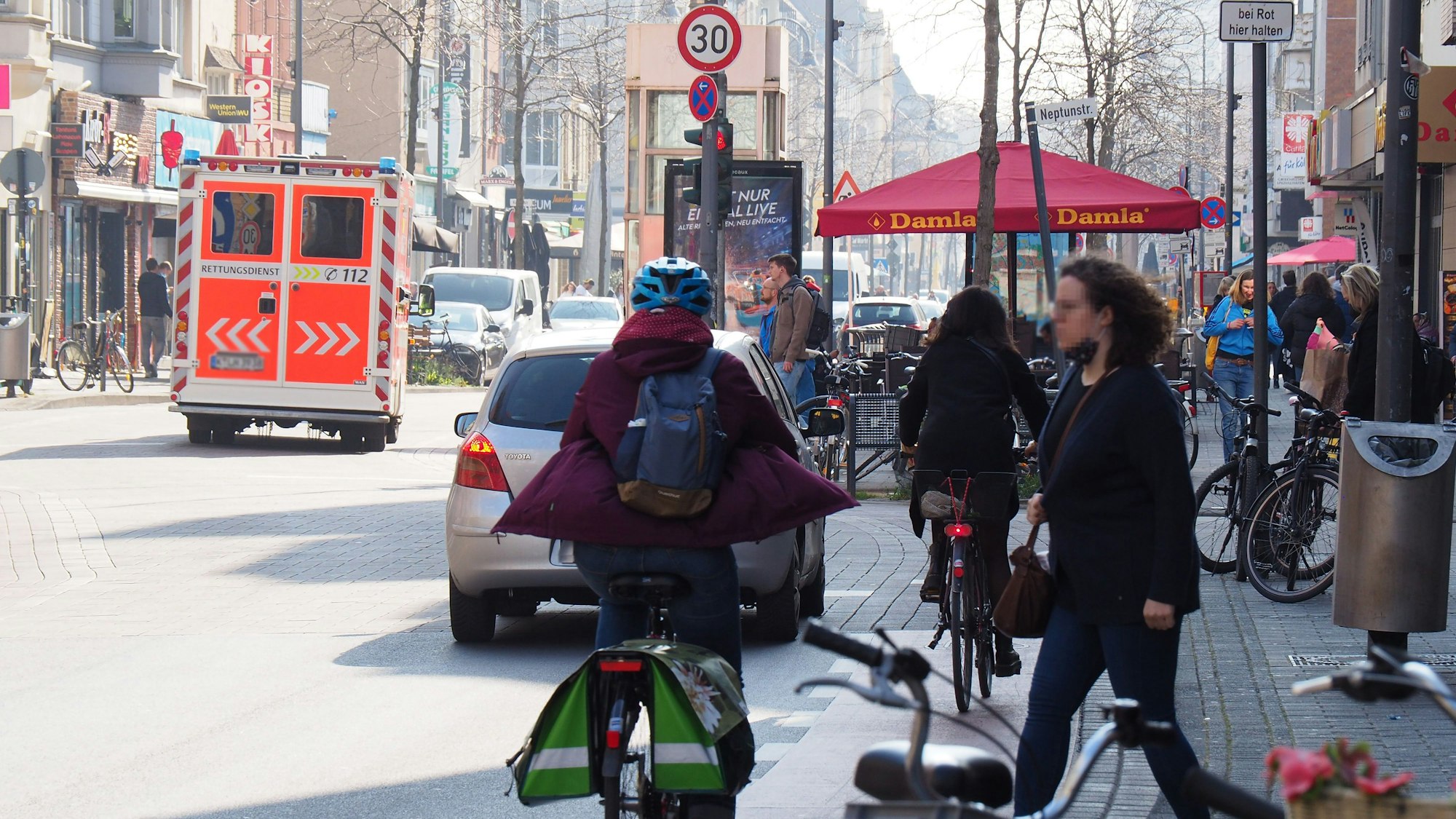 Eine Szene auf der Venloer Straße in Ehrenfeld: Radfahrerende, Fußgänger und Autos.