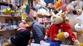 Ein Kind und eine Frau stehen in einem Spielzeugladen.