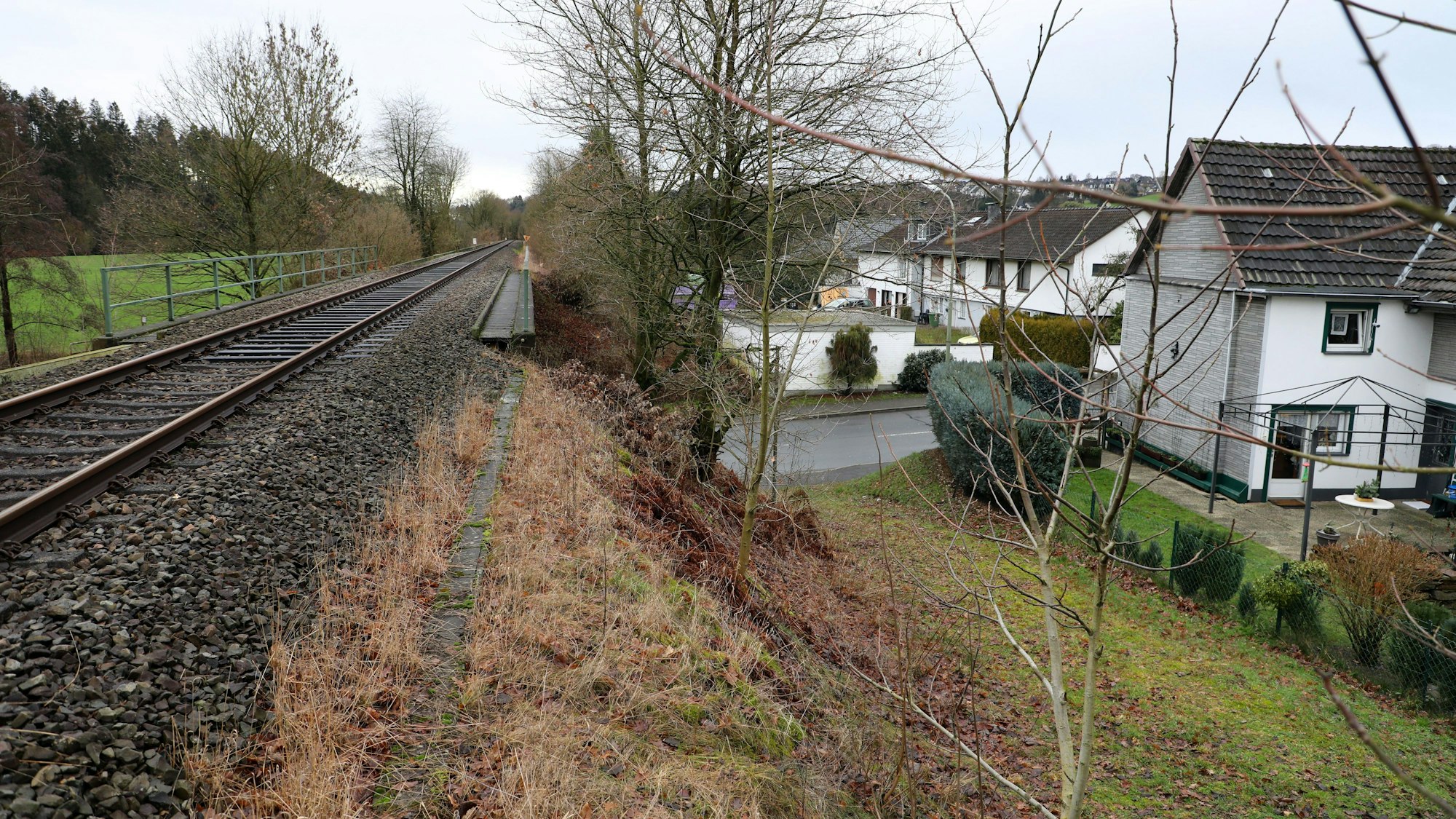 Blick auf Vilkerath: Links eine Schienentrasse, rechts ein Wohngebiet.