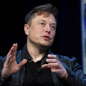 Elon Musk spricht auf einer Konferenz, er gestikuliert mit den Händen.