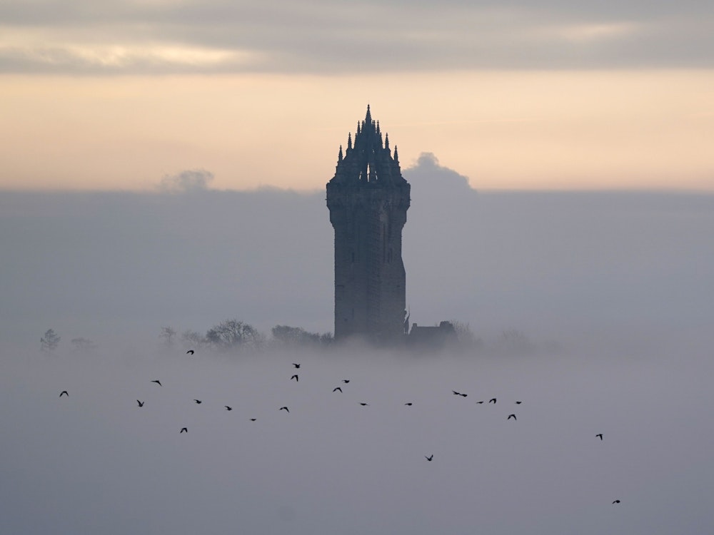 Das Wallace-Denkmal ragt aus dem dichten Nebel heraus, der am Morgen in Stirling über der Landschaft lag.