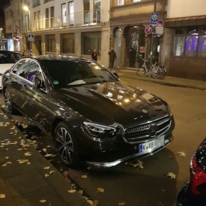 Ein schwarzer Mercedes steht am Straßenrand.