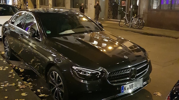 Ein schwarzer Mercedes steht am Straßenrand.