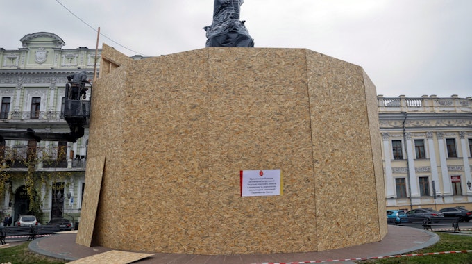 Ein in schwarze Plastikfolie gehüllte Statue hinter einer hohen Schutzwand aus Holz: Das Denkmal in Odessa wartet auf den Abbau und die Verlegung. Das Werk zeigt die Gründer der Stadt mit der Statue von Katharina II. als Schlüsselfigur.