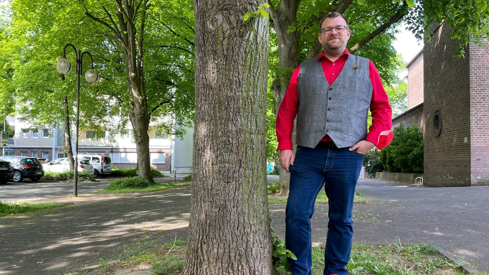 Daniel Dobbelstein steht in Kerpen an einem Baum. Damit möchte er die Wichtigkeit von Umweltthemen deutlich machen.