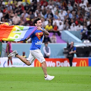 Ein Italiener rannte am Montag mit „Pace“-Regenbogenflagge auf das Feld während des Portugal-Uruguay-Spiels. Er trägt ein Superman-T-Shirt, auf dem vorne „Safe Ukraine“ und hinten „Respect for Iranien Woman“ steht.