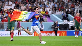 Ein Italiener rannte am Montag mit „Pace“-Regenbogenflagge auf das Feld während des Portugal-Uruguay-Spiels. Er trägt ein Superman-T-Shirt, auf dem vorne „Safe Ukraine“ und hinten „Respect for Iranien Woman“ steht.