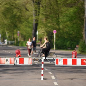 Gesperrte Kitschburger Straße mit Fahrradfahrerin und Fußgängern.