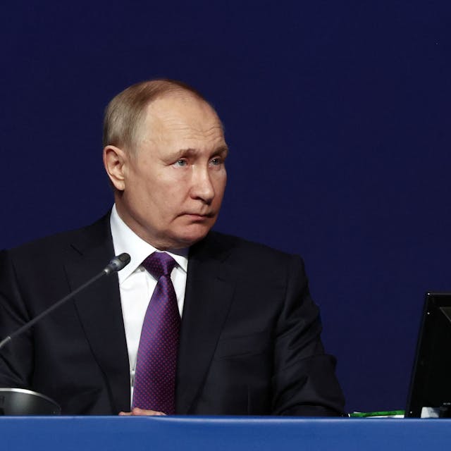 Der russische Präsident Wladimir Putin sitzt bei einer Konferenz an einem Tisch.