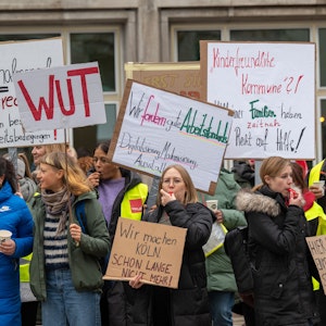 Menschen mit Plakaten in der Hand und Trillerpfeifen wollen erreichen, dass Kinder in Köln besser geschützt werden.